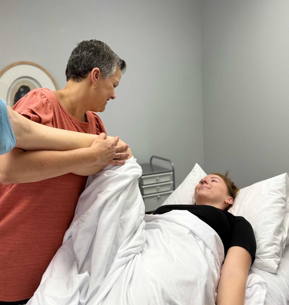 Image showing a lady doing some stretching with the help of a therapist